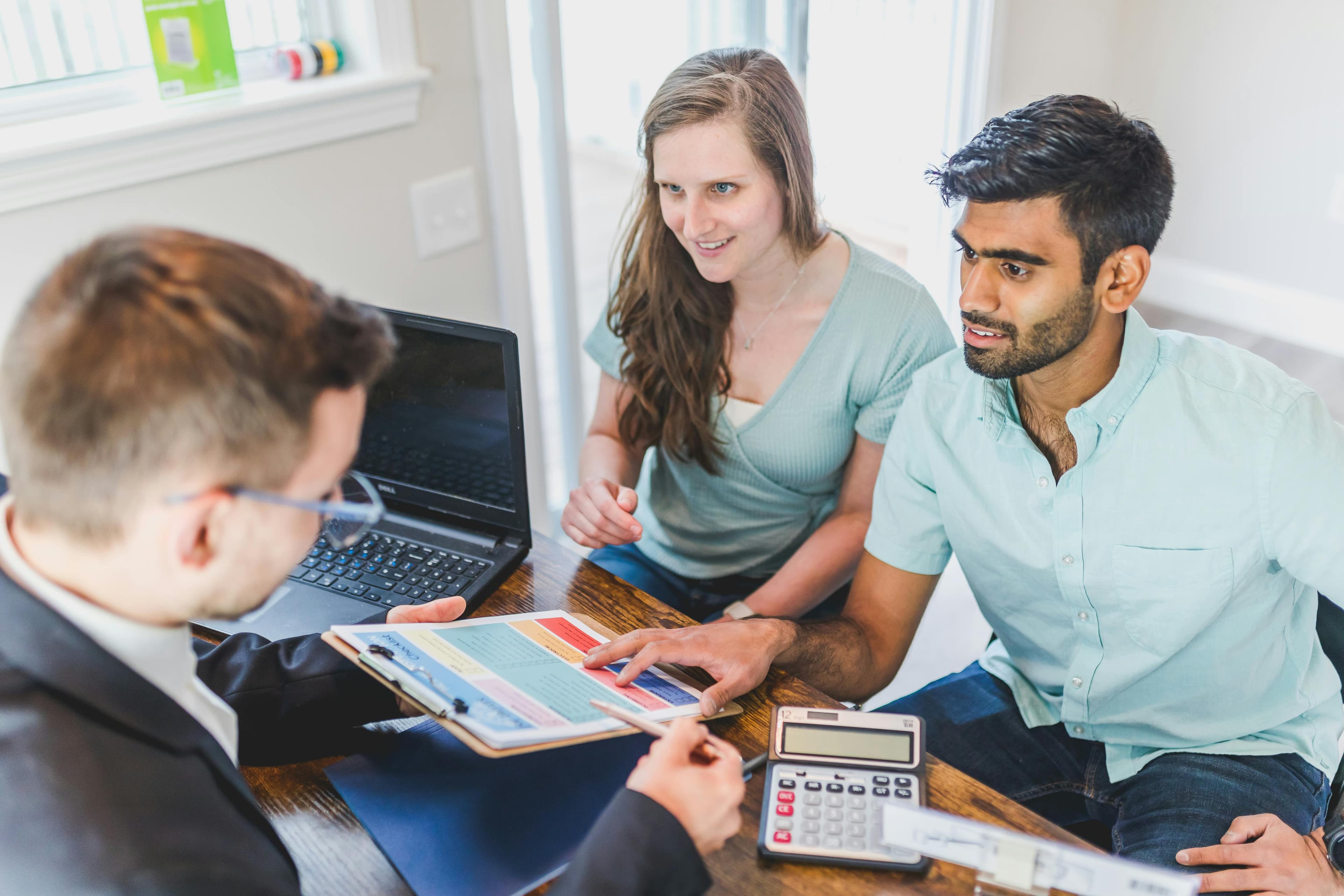 Two people reviewing first-home documents with an agent
